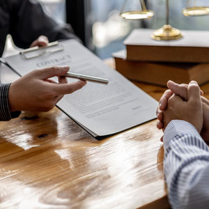  A trust litigation attorney is handing the women a paper to sign.